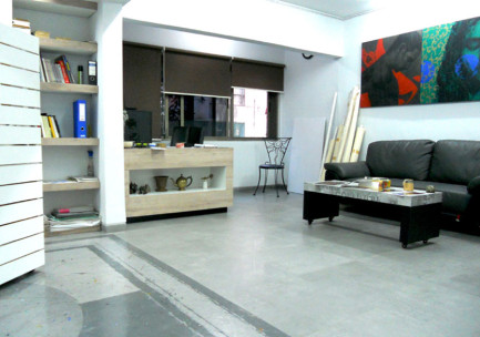 Relaxing lounge space of the art studio with paintings hanging on the wall
